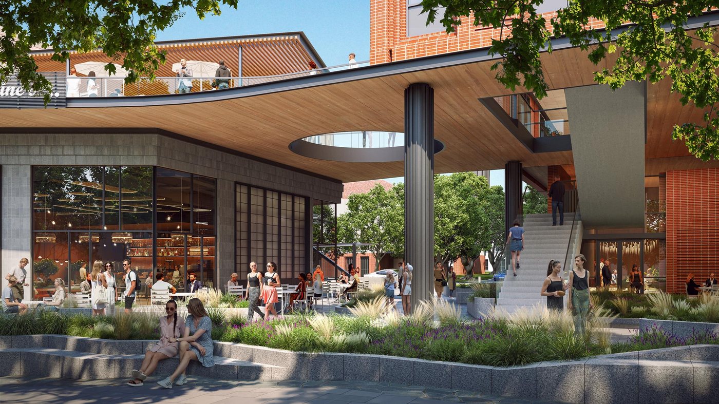 A warmly lit café-lined street at dusk, evoking the neighborhood energy Areté is designed around